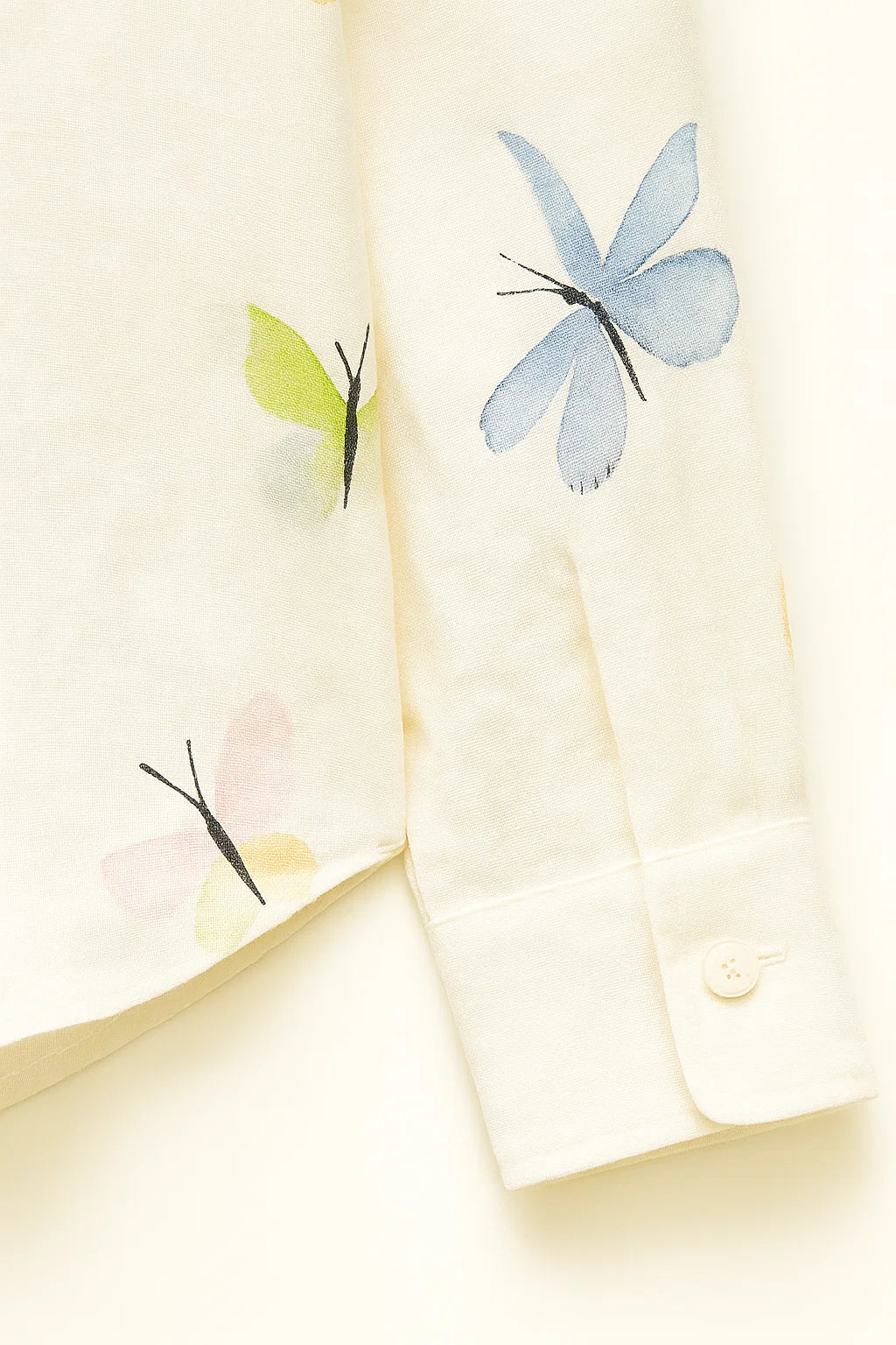 Moda femenina: Camisa blanca casual con estampado de mariposas, manga larga y botones. Versátil y cómoda.