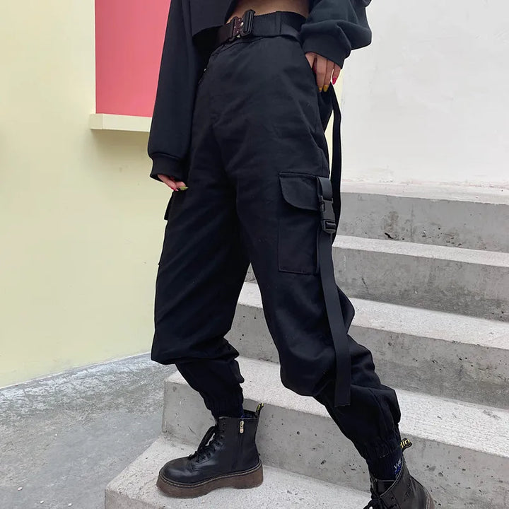 Mujer luciendo pantalón cargo negro de cintura alta con cinturón y bolsillos, estilo casual versátil.