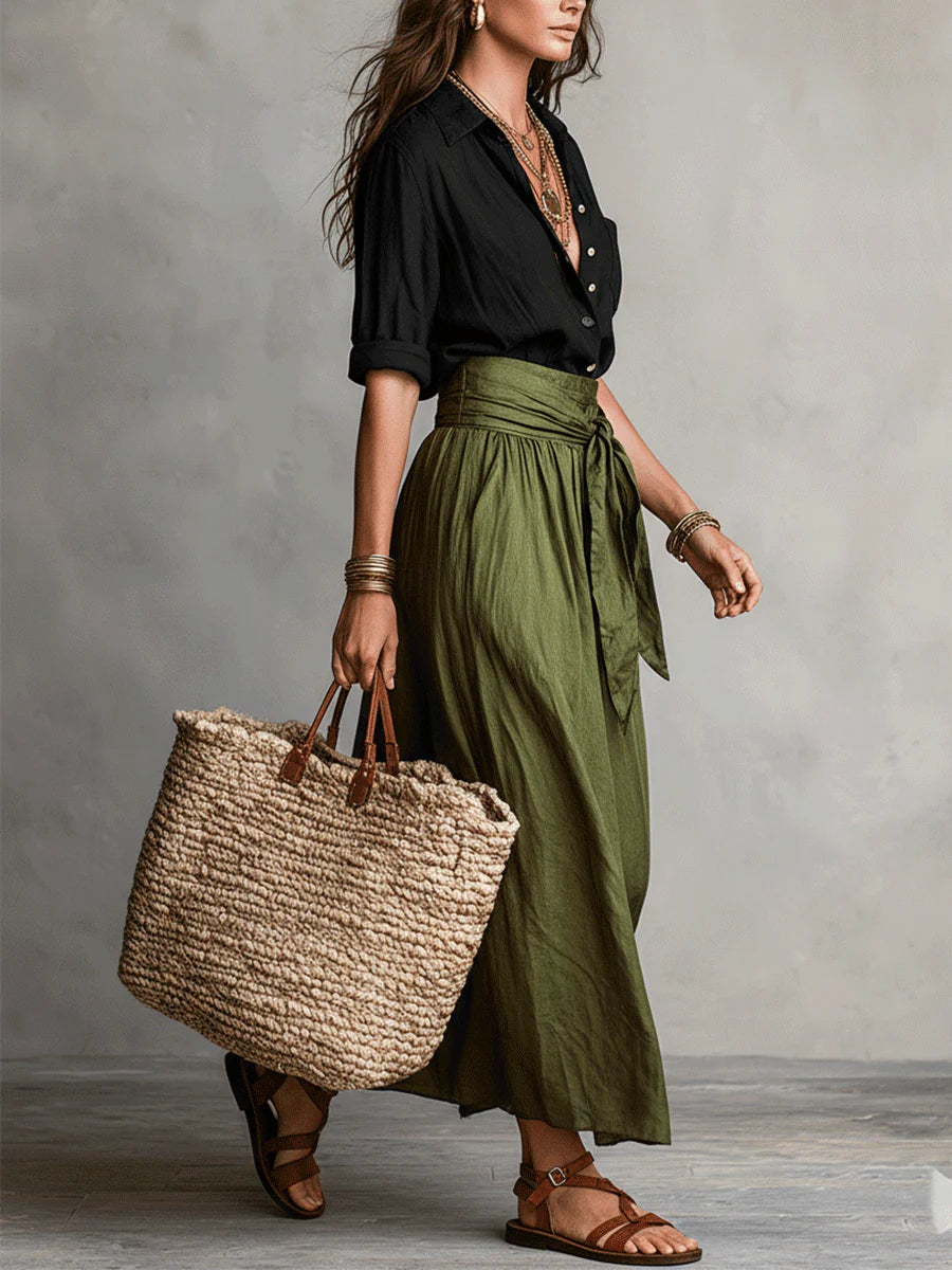 Mujer vistiendo conjunto de dos piezas: camiseta negra y falda midi verde olivo, moda femenina y versátil.