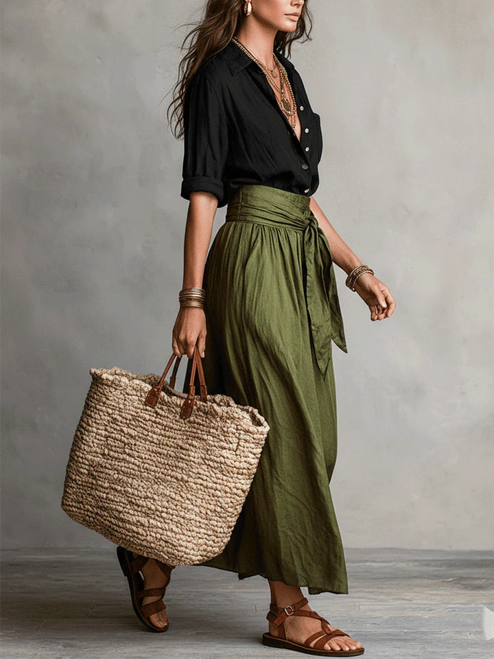 Mujer vistiendo conjunto de dos piezas: camiseta negra y falda midi verde olivo, moda femenina y versátil.