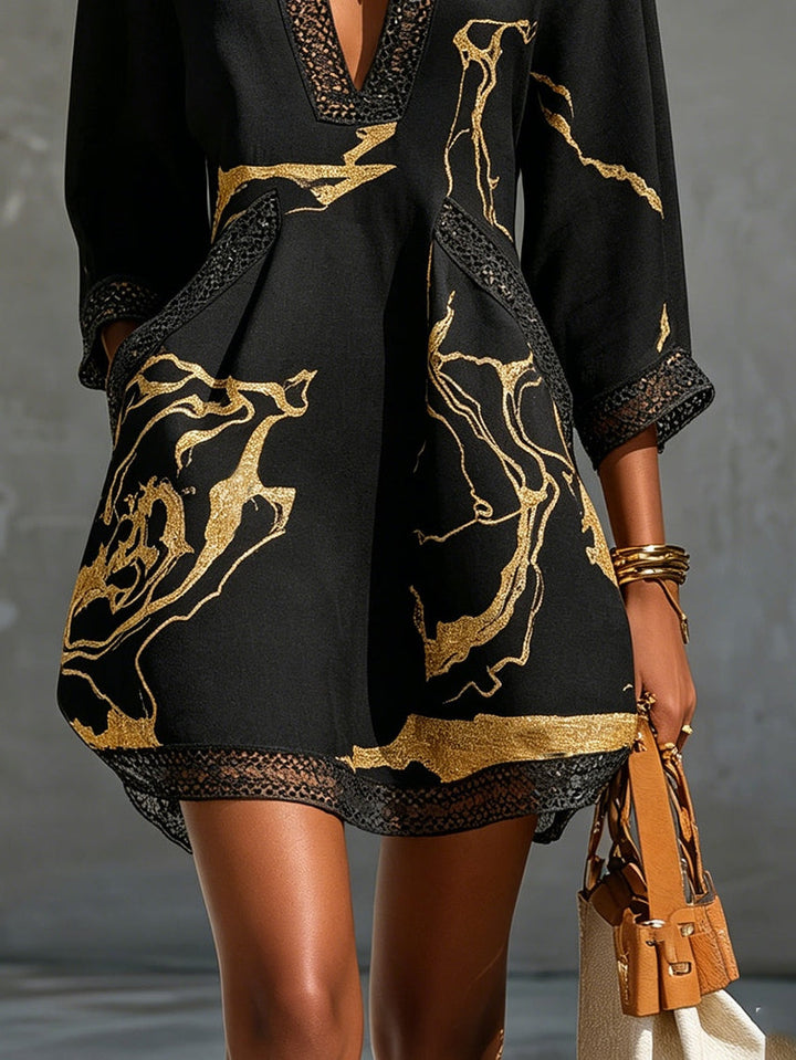 Vestido mini de mujer negro con encaje en escote V, manga 3/4, y estampado dorado. Estilo elegante.