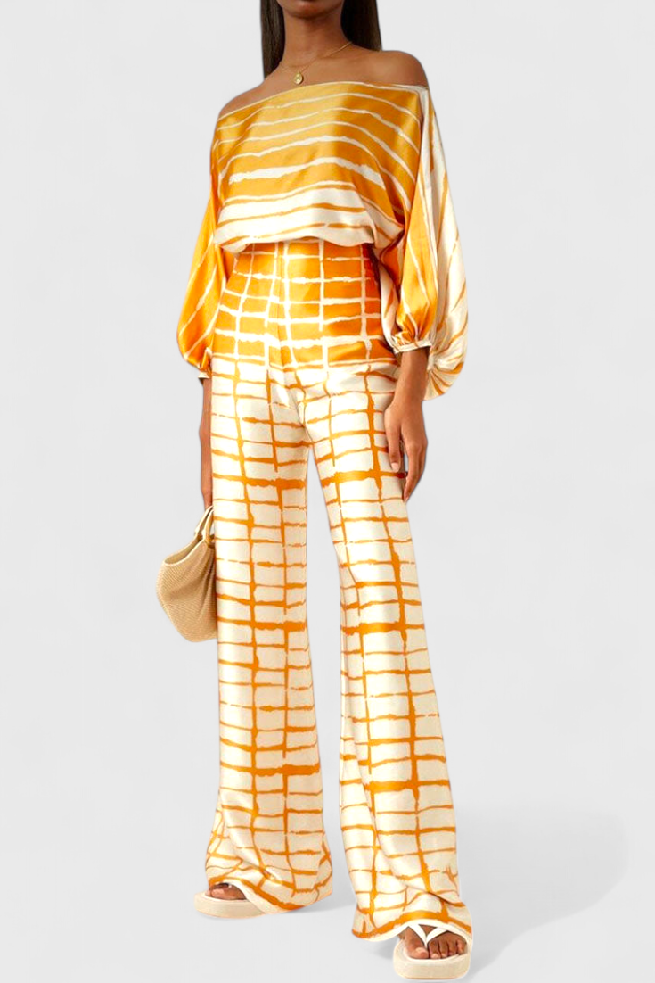 Elegante conjunto casual de mujer: blusa de hombros caídos y pantalones anchos estampados. Outfit cómodo para verano.