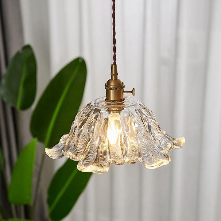 Lámpara de techo de lujo con vidrio dorado y forma de flor, creando iluminación moderna.