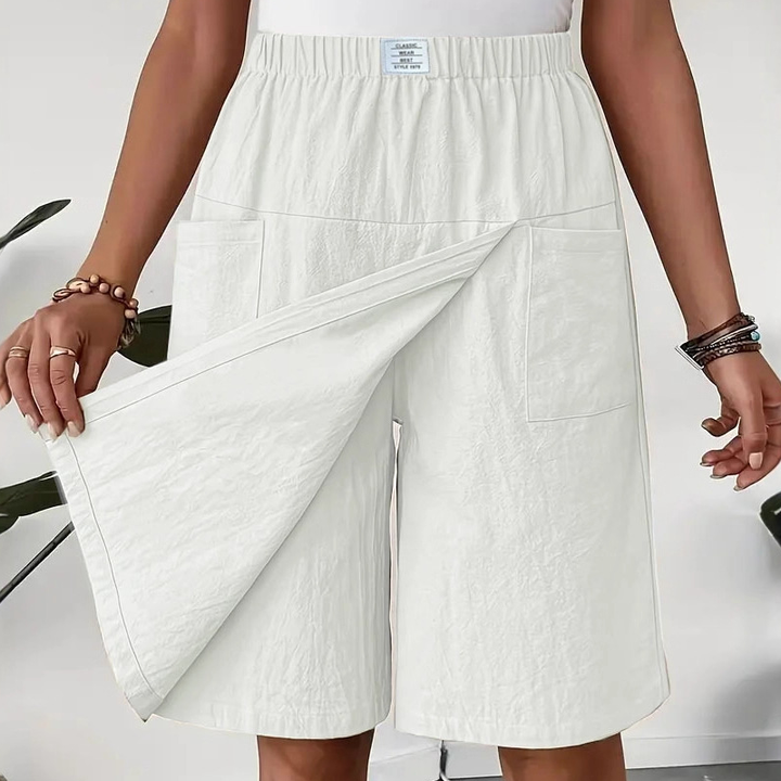Mujer luciendo pantalón corto con falda superpuesta, estilo moderno y veraniego. Ideal para vacaciones.