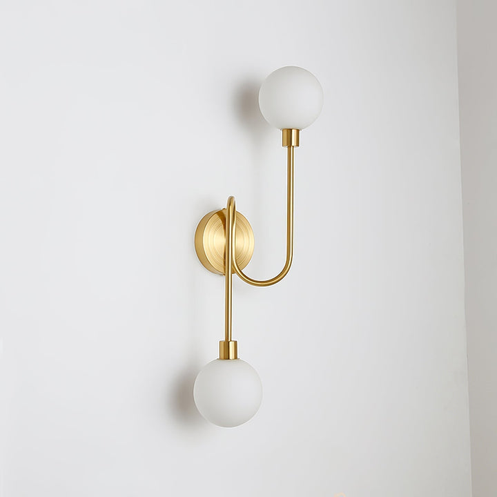 Foco de pared de latón con dos globos esféricos de cristal blanco. Luminaria elegante.