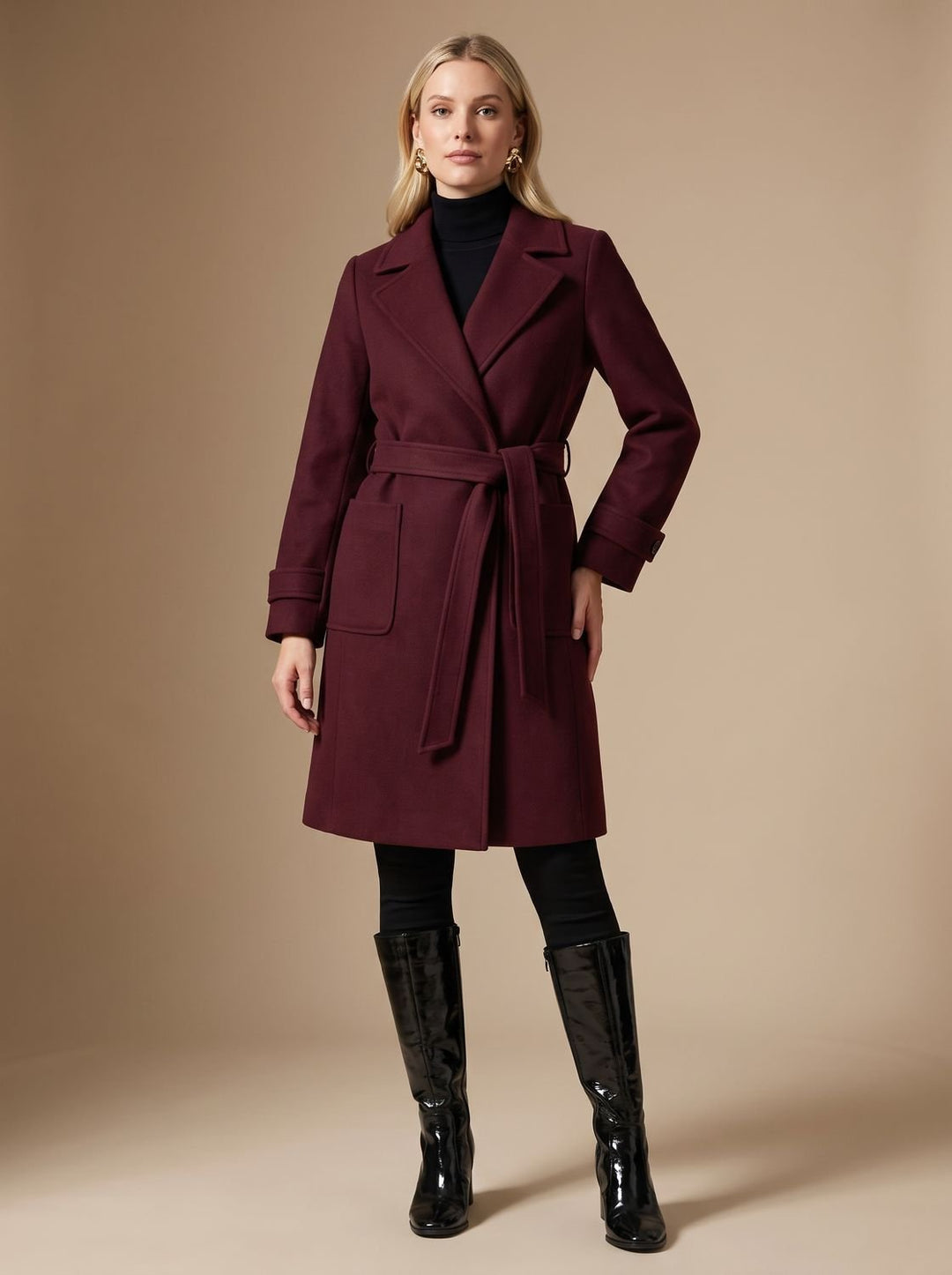 Mujer luciendo abrigo largo burdeos cruzado con cinturón. Ropa de abrigo elegante para invierno.