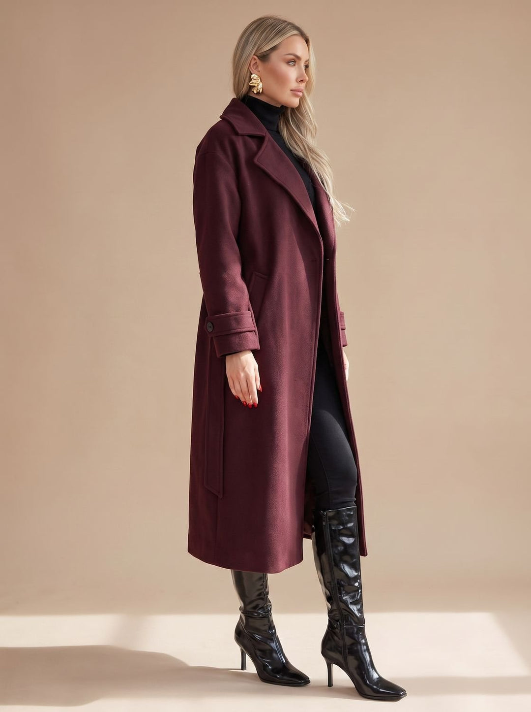 Detalle de abrigo largo burdeos de mujer, cruzado. Con cinturón que realza la figura, ideal invierno.