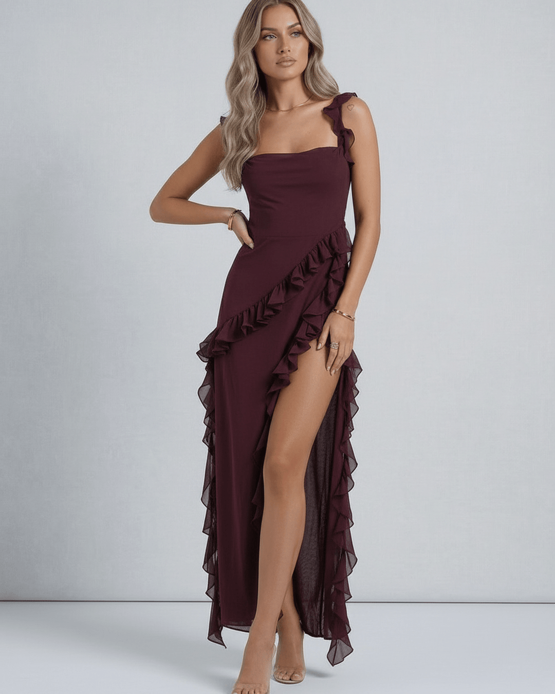 Vestido de noche maxi blanco con dobladillo asimétrico y volantes, diseño fluido y sofisticado para mujer.