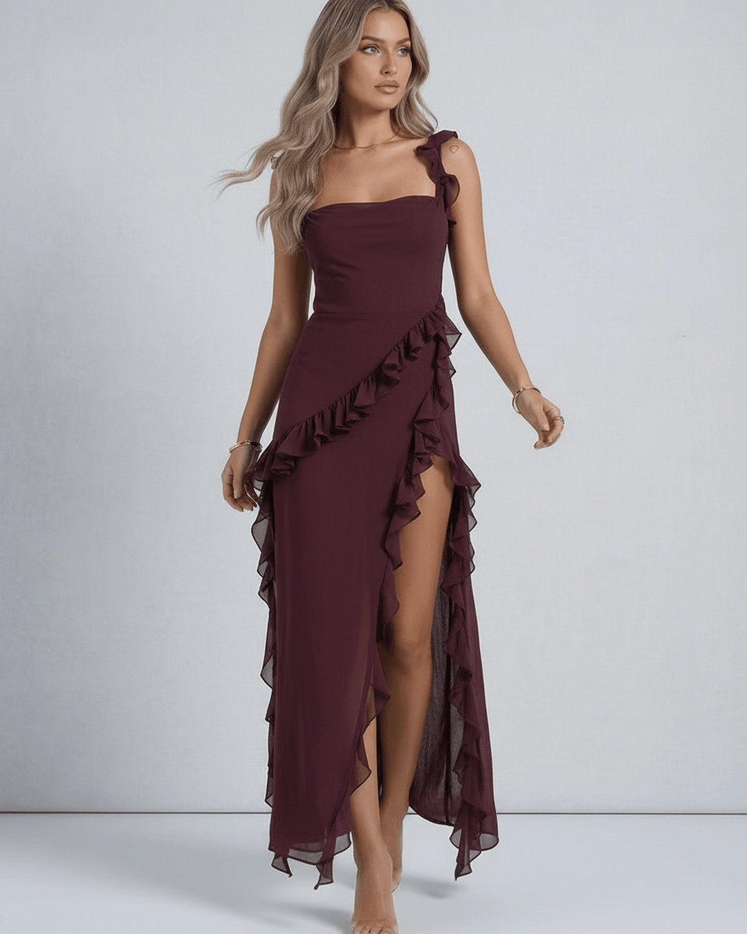 Vestido maxi blanco para mujer, estilo sofisticado y fluido, con detalles de volantes y dobladillo asimétrico.
