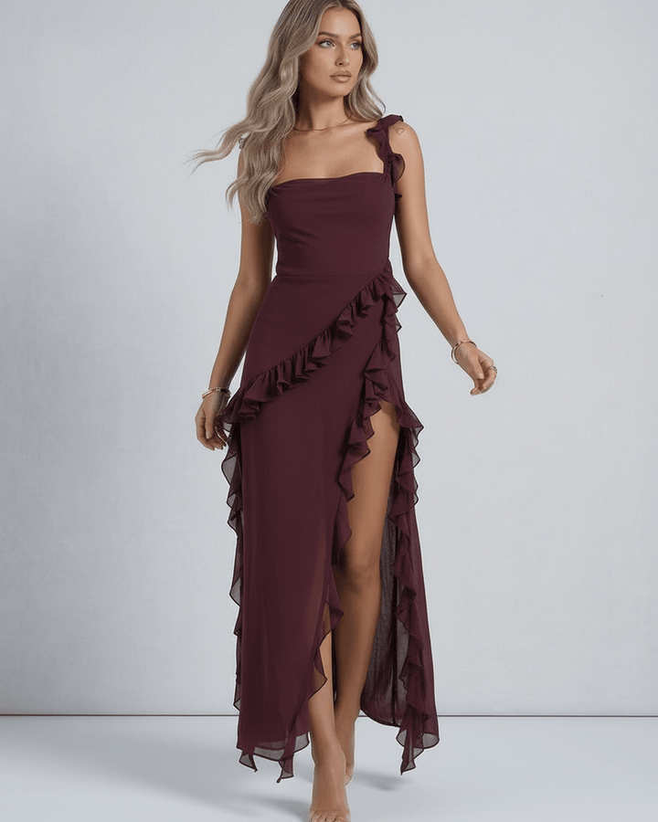 Vestido maxi blanco para mujer, estilo sofisticado y fluido, con detalles de volantes y dobladillo asimétrico.