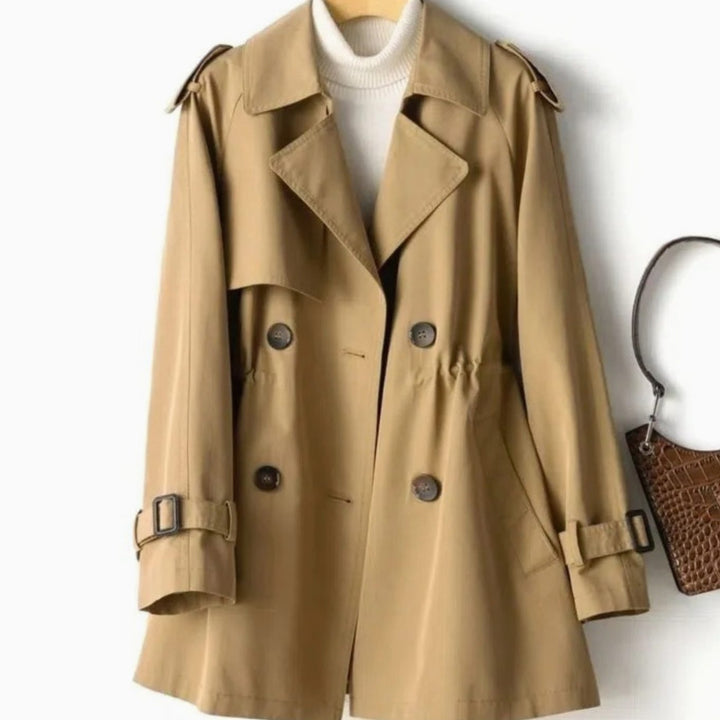 Mujer luciendo gabardina cruzada ANOUK, abrigo versátil y elegante para el estilo de otoño-invierno.