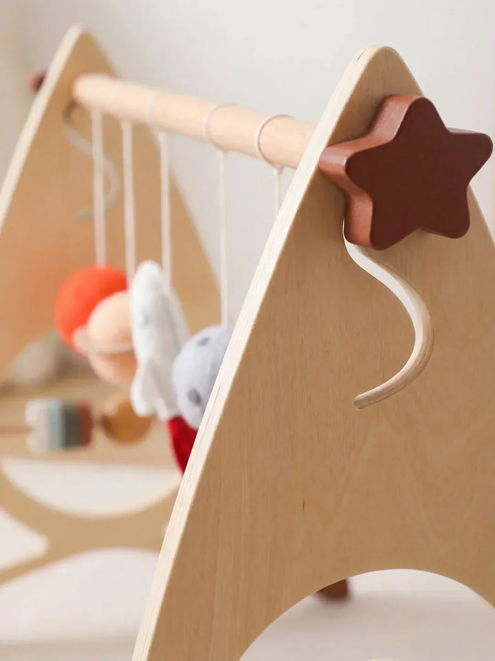 Arco de juegos de madera con elementos sensoriales. Cohete y estrellas. Perfecto para bebés exploradores.