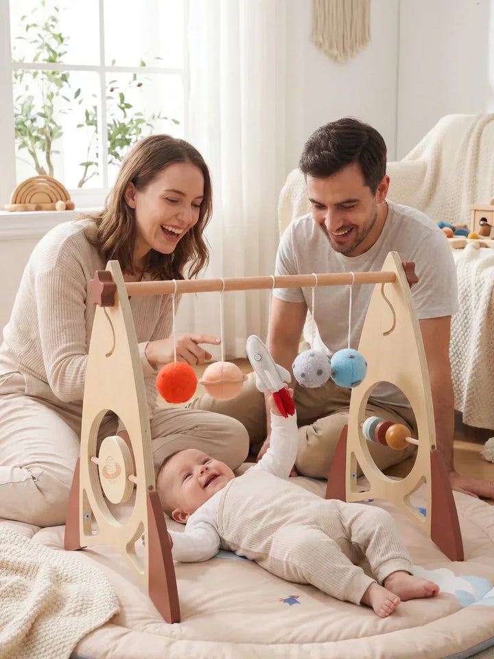 Estimulación temprana con arco de juegos de madera. Cohete y estrellas. Juguete sensorial para bebés.