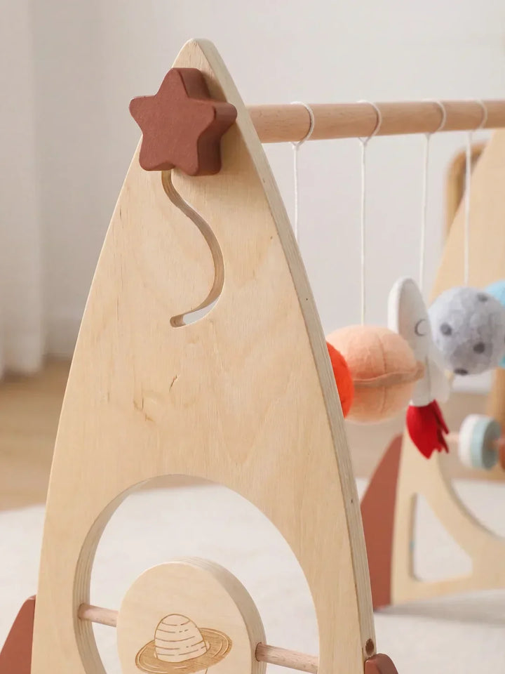 Desarrollo infantil seguro con arco de juegos de madera. Cohete y estrellas. Gimnasio sensorial.