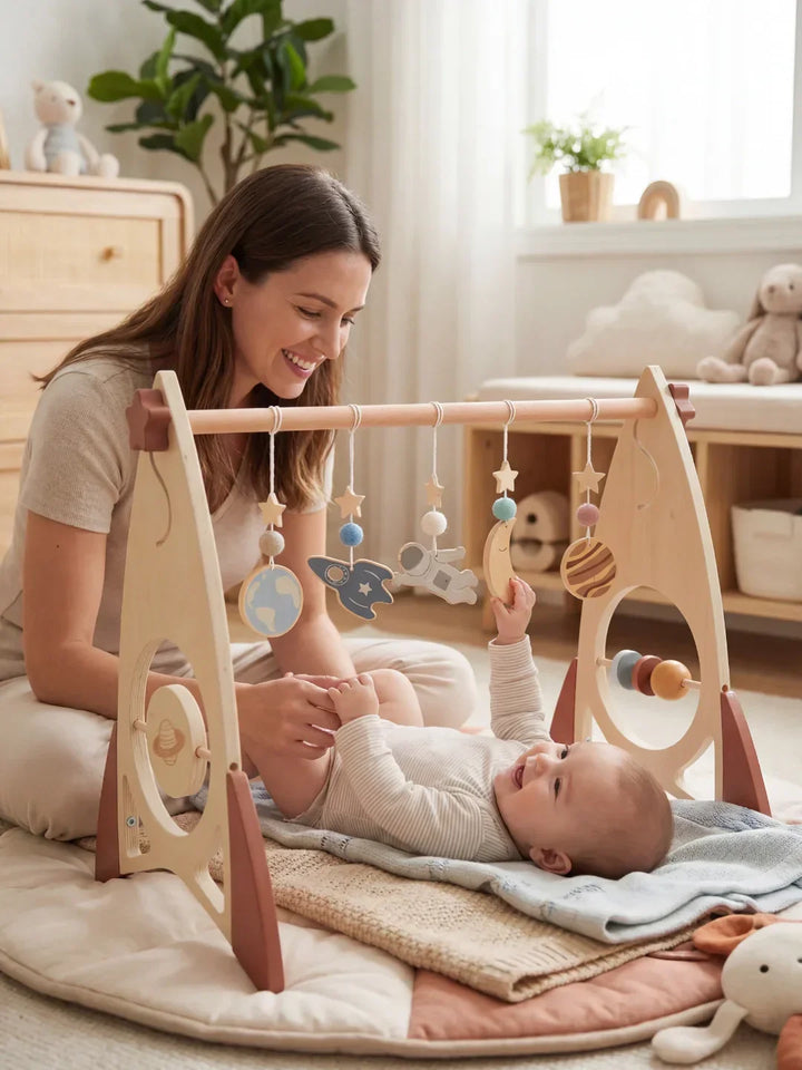 Bebé jugando con arco de madera. Cohete y estrellas. Juguete sensorial que promueve el desarrollo.