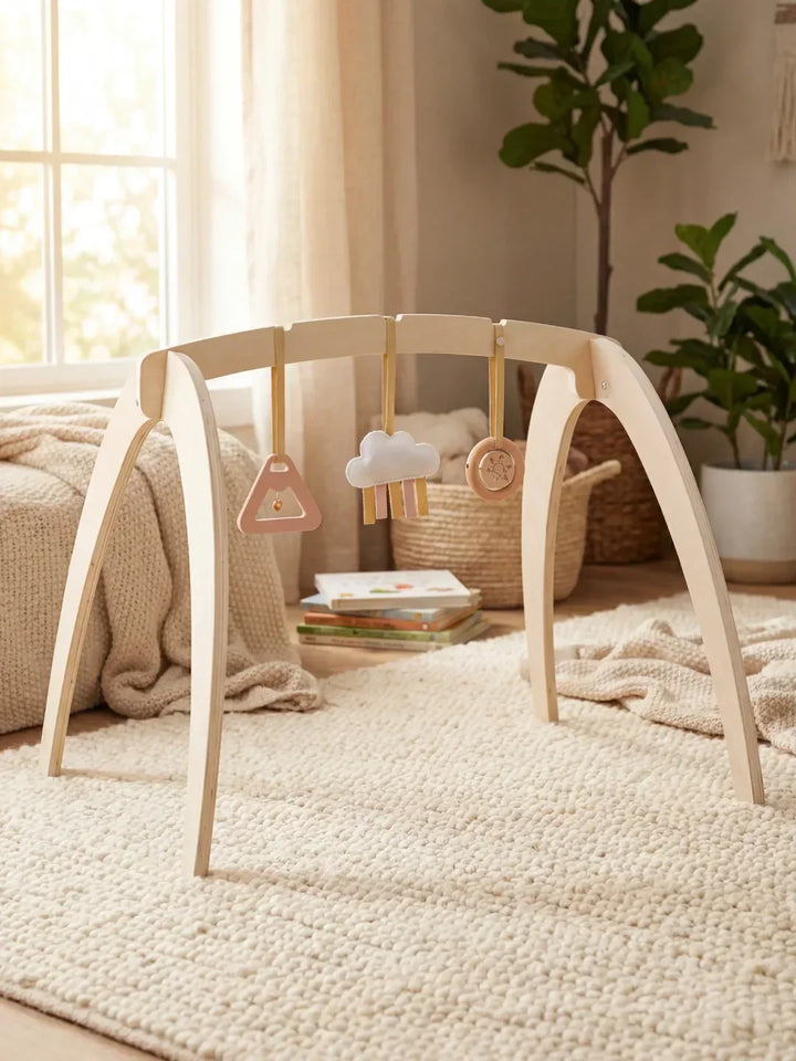Arco de juego sensorial de madera para bebés, con juguetes colgantes que invitan a explorar.