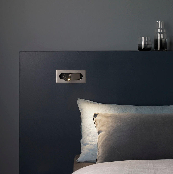 Aplique de pared moderno para lectura nocturna. Ofrece iluminación regulable en tu dormitorio.