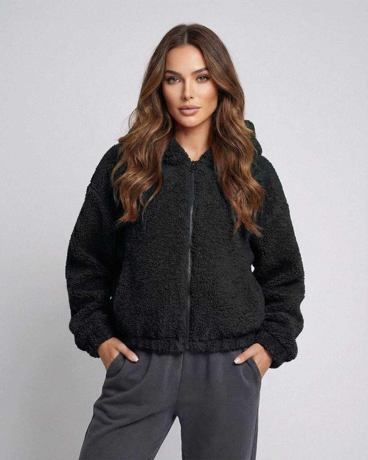 Chaqueta corta negra de mujer con capucha, ideal para estilo urbano y casual, combina confort y moda.