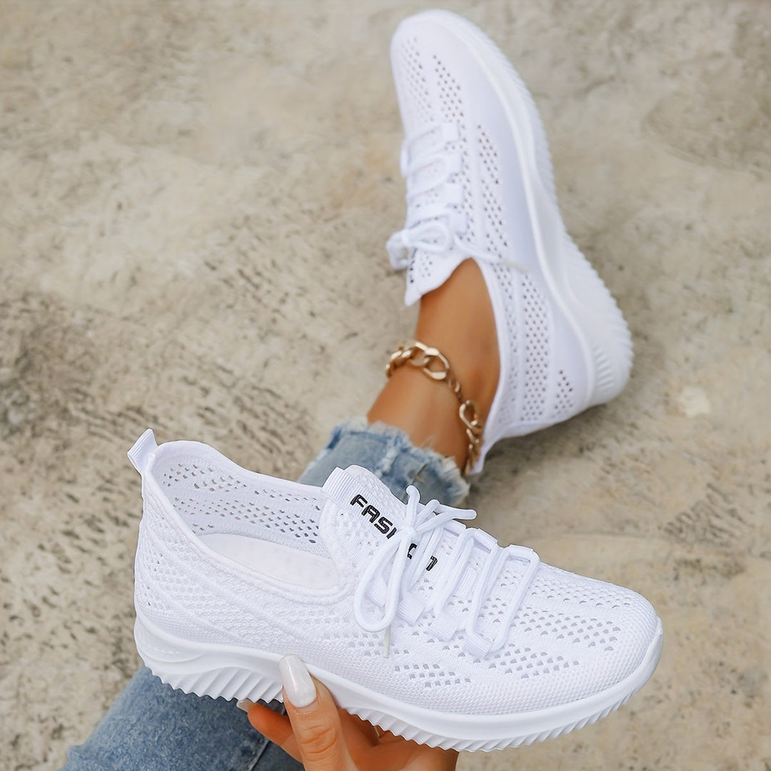 Par de zapatillas blancas para mujer, con tejido transpirable y suela ligera que ofrece excelente amortiguación.