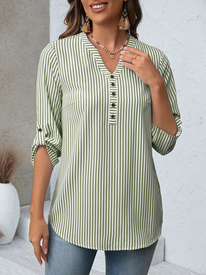 Detalle de blusa de rayas para mujer, cuello en V, botones frontales, textura ligera.