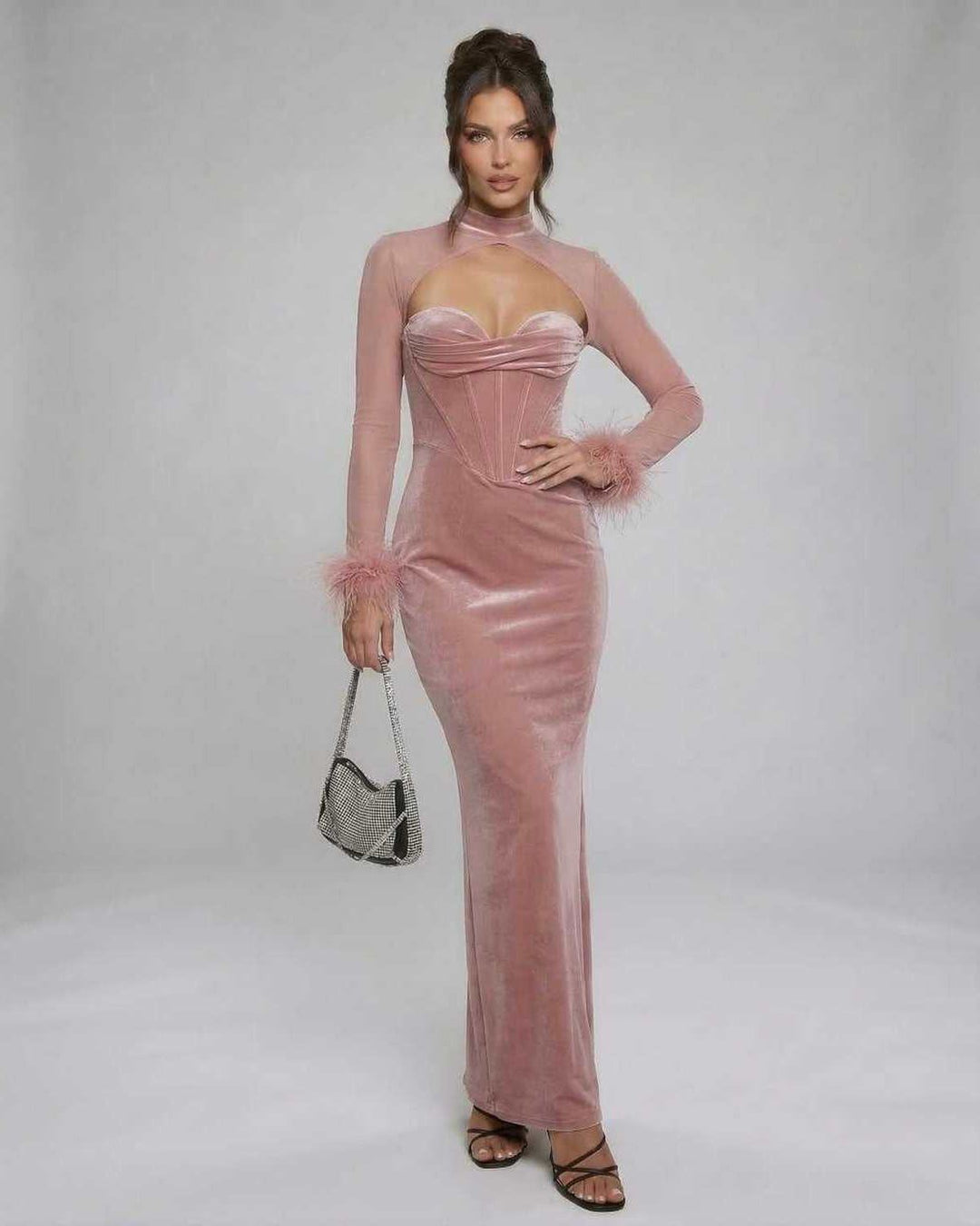 Vestido largo elegante de mujer, tono rosa pálido, con plumas en puños. Perfecto para gala o evento formal.