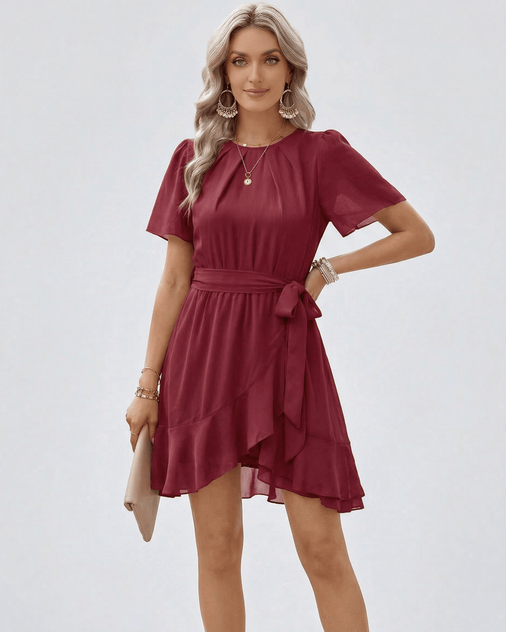 Mujer luciendo vestido mini burdeos con volantes. Estilo elegante y ajustable, perfecto para eventos casual chic.