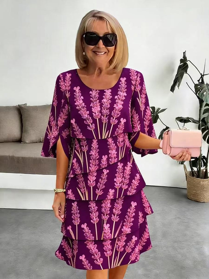 Vestido midi lavanda con estampado floral, volantes escalonados y mangas abiertas. Diseño moderno y fluido para mujer.