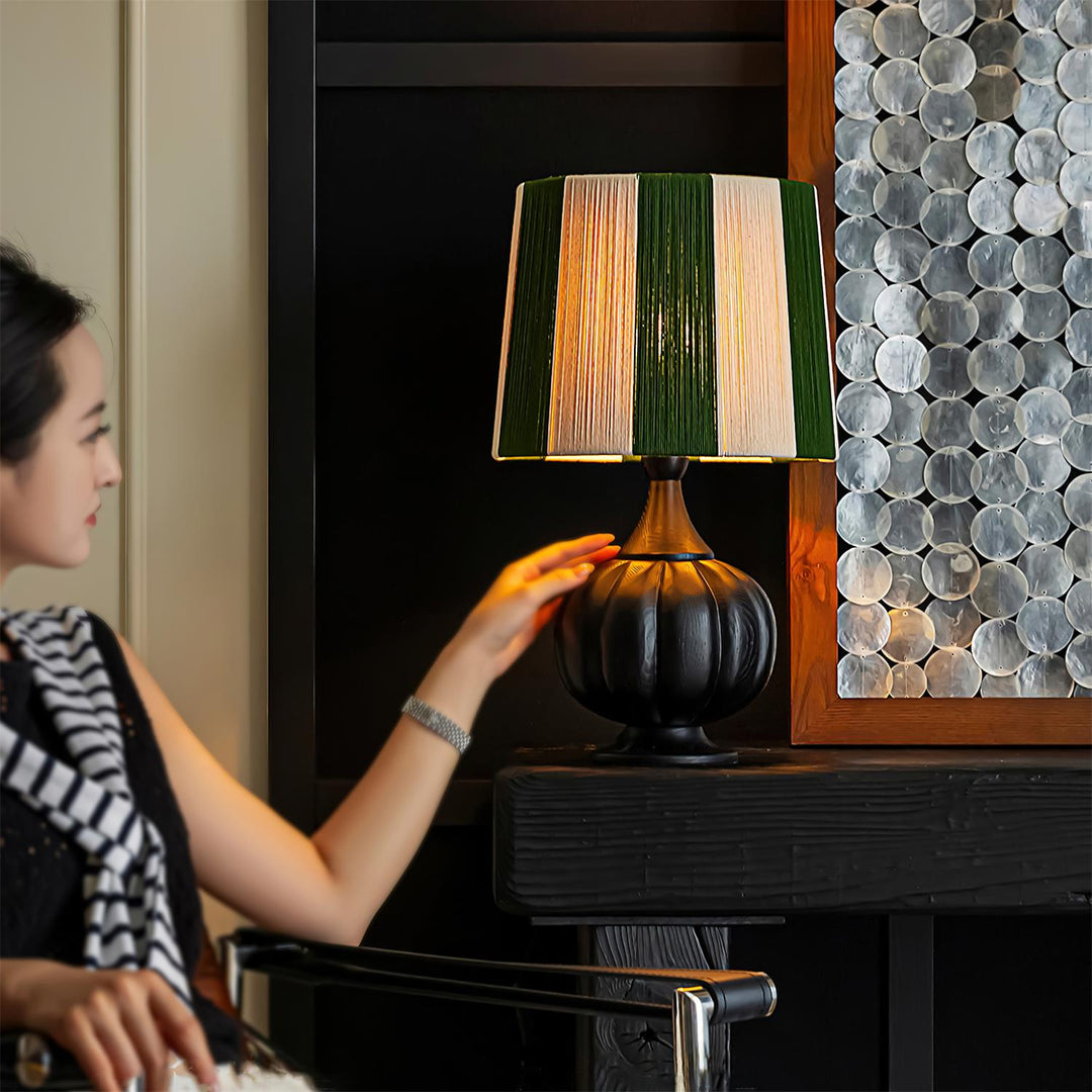 Lámpara de mesa con estilo, diseño a rayas y robusta base de madera, para una decoración actual.