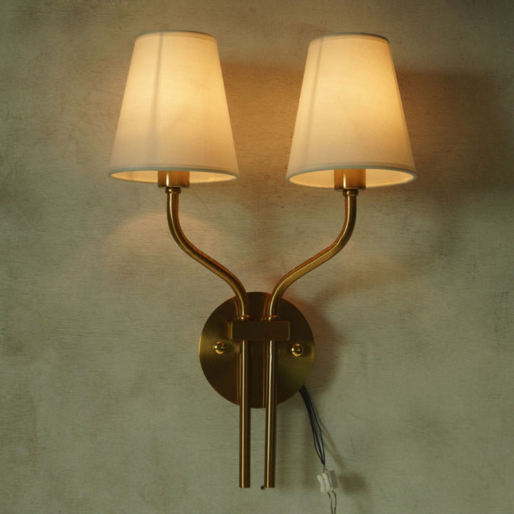 Detalle de lujo con aplique de pared dorado doble; crea un ambiente cálido en tu dormitorio.