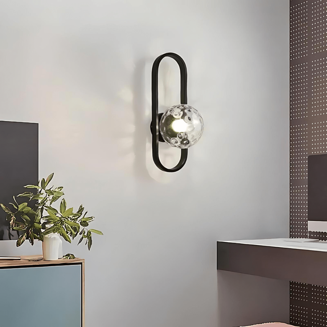 Aplique moderno de pared en metal negro y vidrio, luz bidireccional para ambientes interiores elegantes.