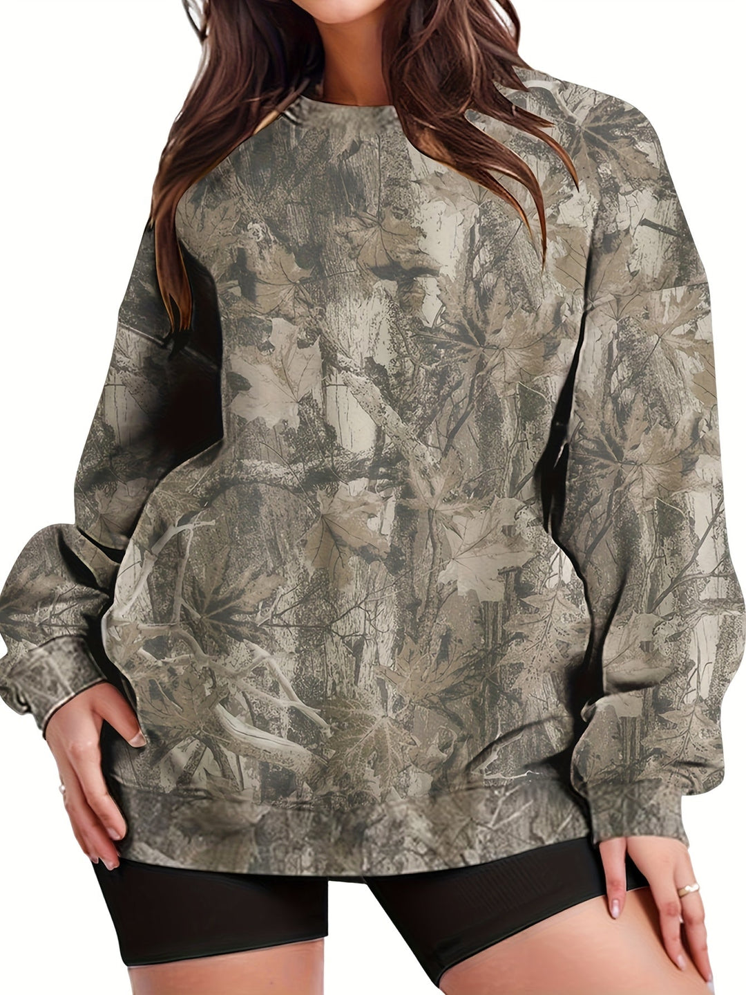 Espalda de mujer con sudadera holgada camuflaje UrbanLeaf. Puños acanalados, estilo relajado.