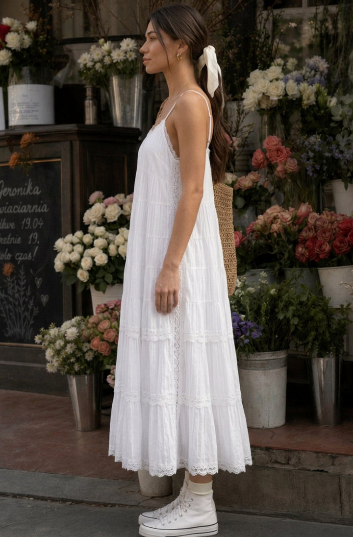 Vestido midi de algodón bohemio blanco con tirantes finos. Diseño escalonado y encaje, ideal para el verano de mujer.