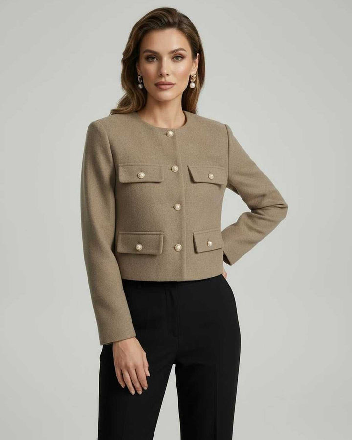 Mujer luciendo chaqueta entallada celeste con botones dorados. Look profesional y chic para la temporada.