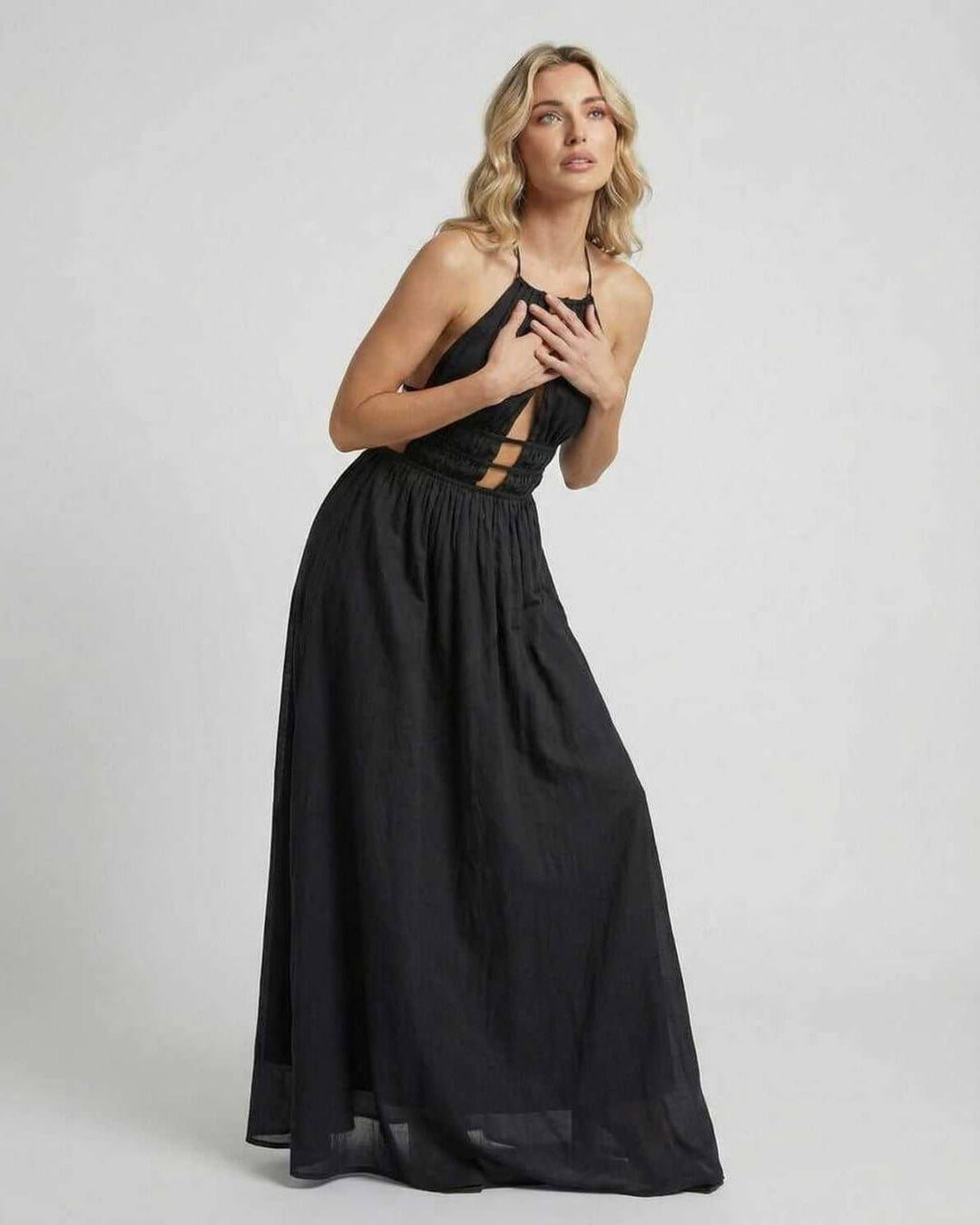 Vestido maxi blanco liso con cuello halter en maniquí. Ropa elegante de mujer para eventos.