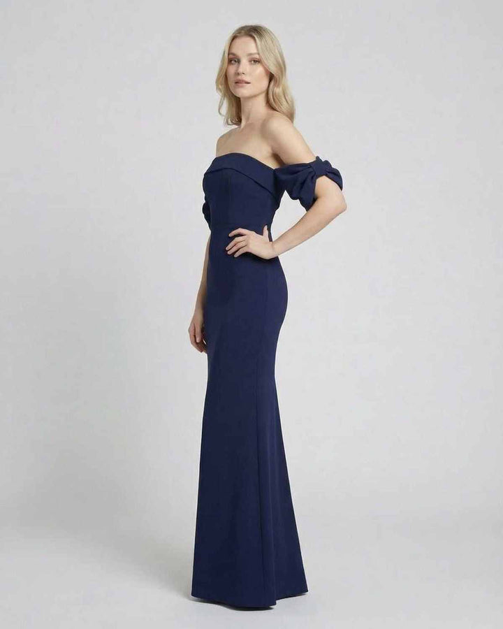 Mujer luciendo vestido maxi bodycon celeste con hombros descubiertos, silueta elegante y espalda abierta.