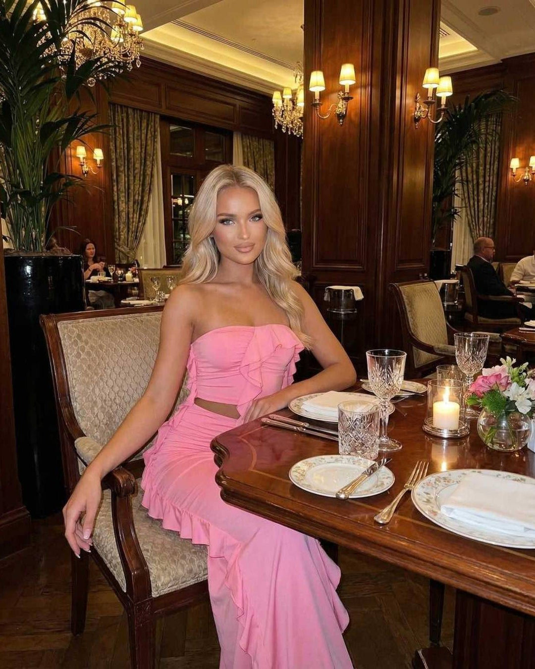 Mujer luciendo un vestido maxi blanco elegante sin tirantes y volantes. Moda de fiesta y verano para mujer.