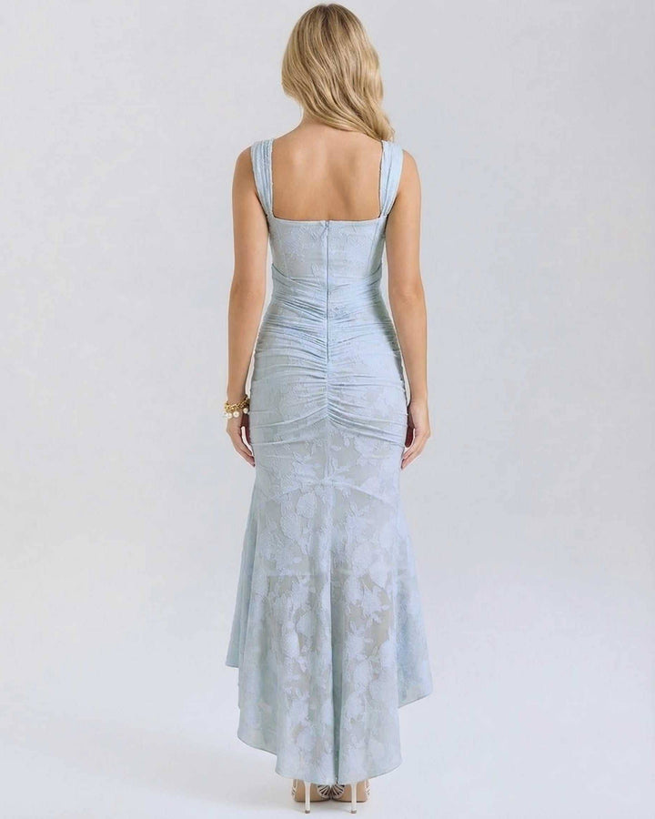 Mujer luciendo vestido maxi celeste jacquard sin mangas. Estilo elegante, dobladillo asimétrico para ocasión especial.