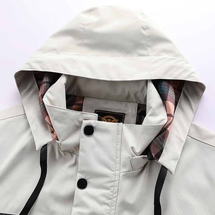 Hombre con chaqueta cortavientos, multibolsillos, ideal para viaje y uso casual en la ciudad.