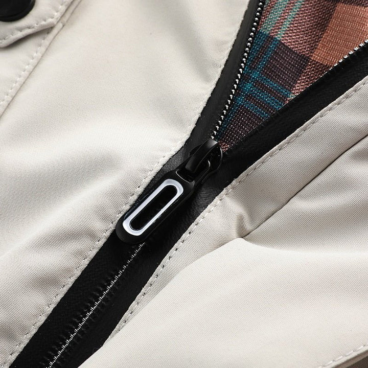 Chaqueta cortavientos oscura de hombre, multibolsillos. Estilo casual funcional, moda urbana de otoño.