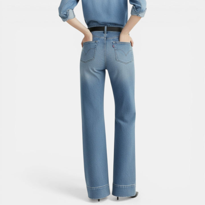 Pantalones vaqueros holgados de mujer, vista lateral. Comodidad y estilo urbano en mezclilla.