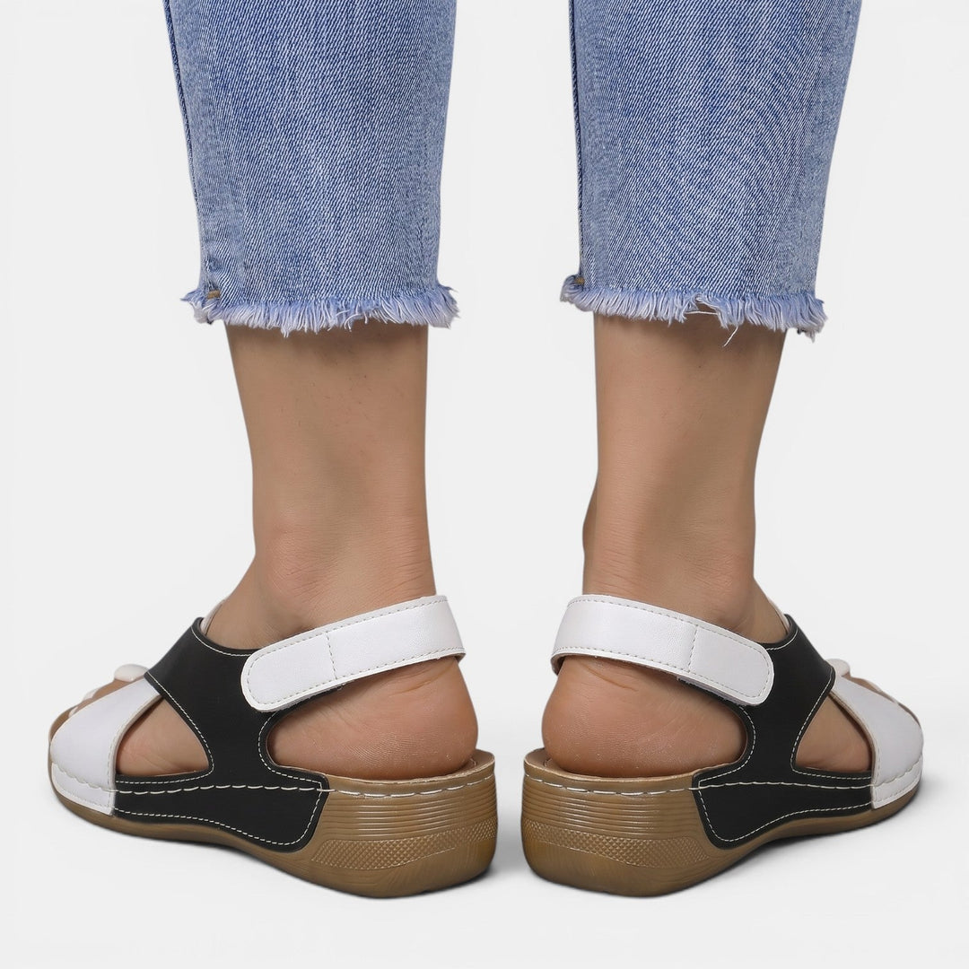 Mujer luciendo sandalias de cuña cómodas, estilo casual elegante, perfectas para paseos de verano.