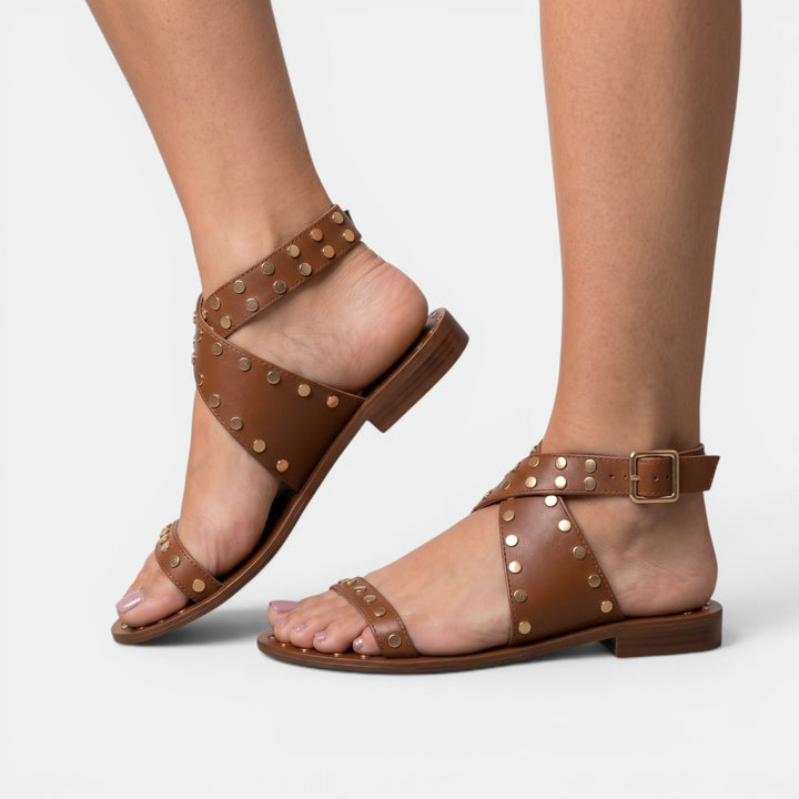 Calzado de mujer: sandalias planas con tachuelas, estilo elegante y cómodo, ideal para el verano y la playa.