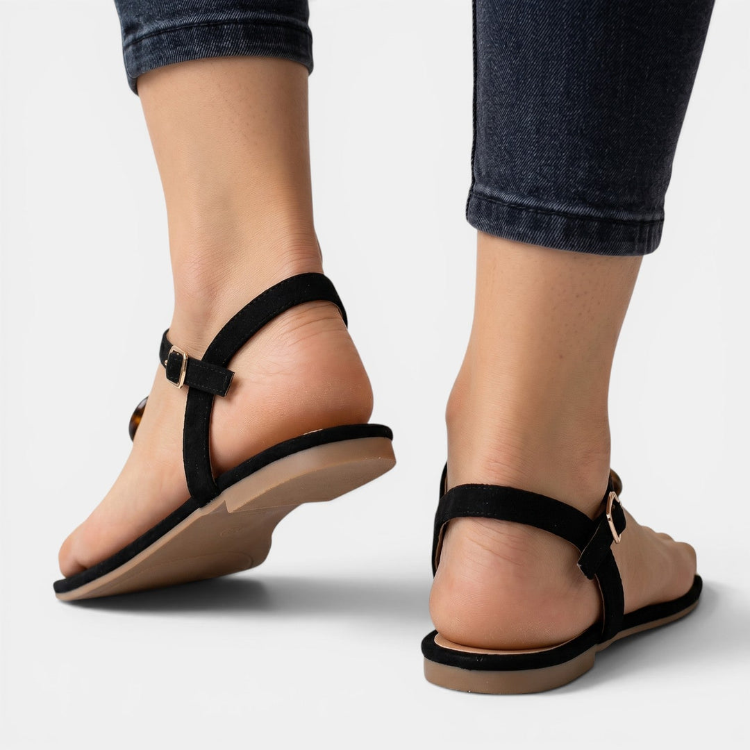 Mujer disfrutando el verano con sandalias planas cómodas y casuales, ideales para la playa o vacaciones.