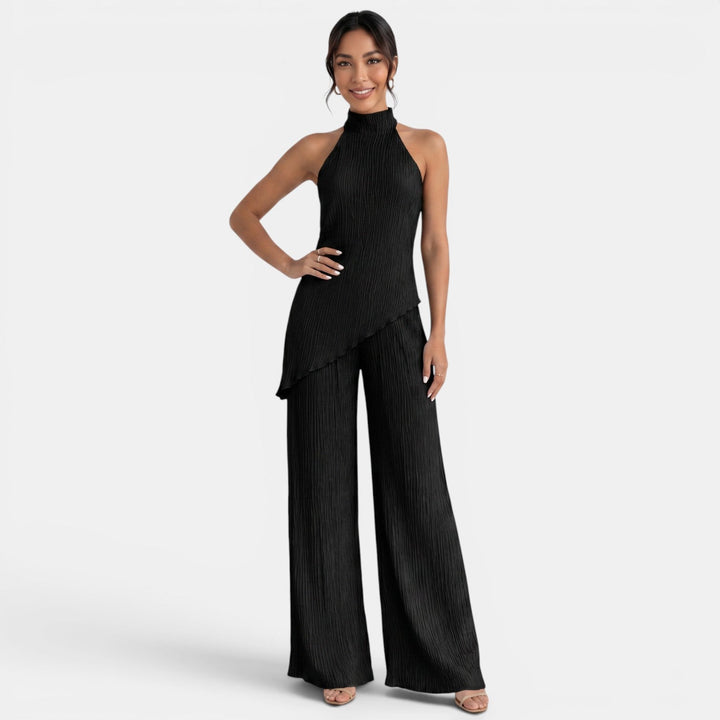 Detalle de top halter y pantalón plisado en conjunto de moda femenina. Estilo sofisticado.