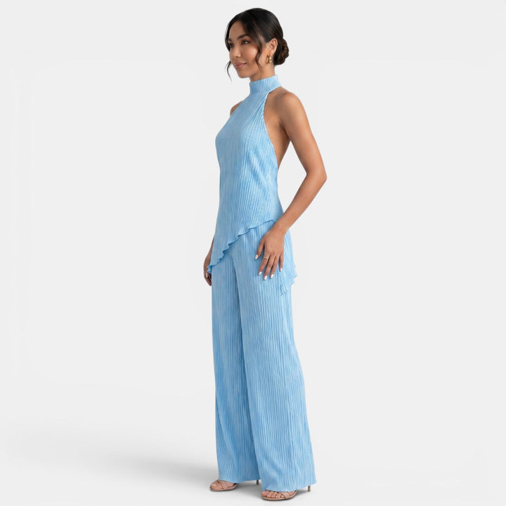Modelo posando con conjunto de mujer halter y pantalón plisado. Moda femenina para ocasiones especiales.