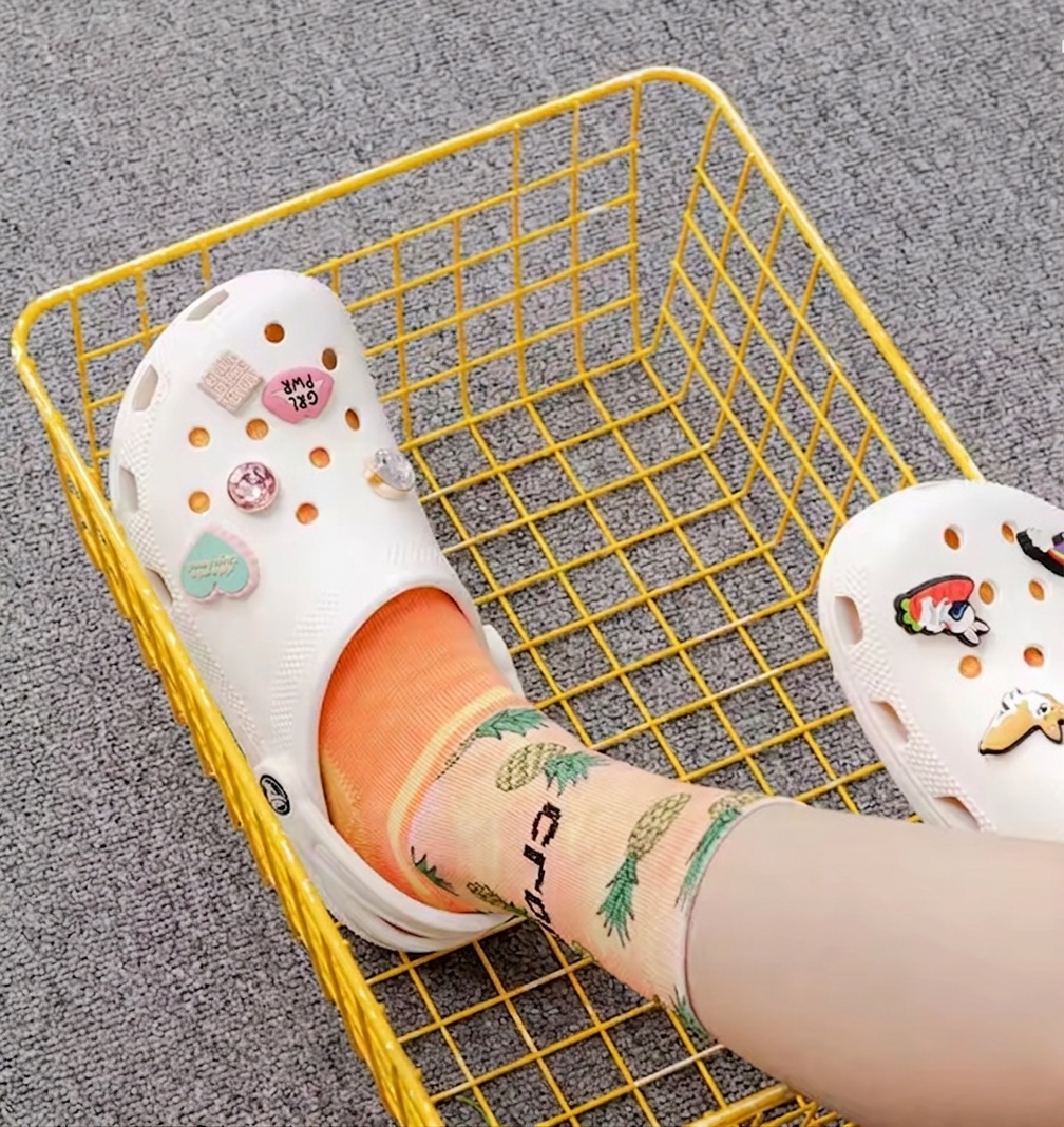 Hombre usando zuecos Crocs clásicos, calzado ventilado y ligero para paseos casuales de verano.