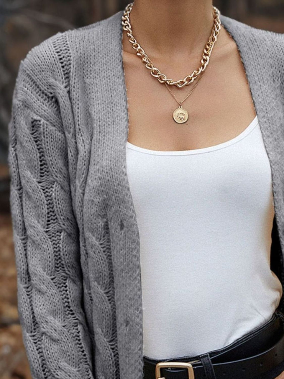 Suéter de mujer con punto trenzado y botones, ideal para un estilo casual y cómodo en invierno.