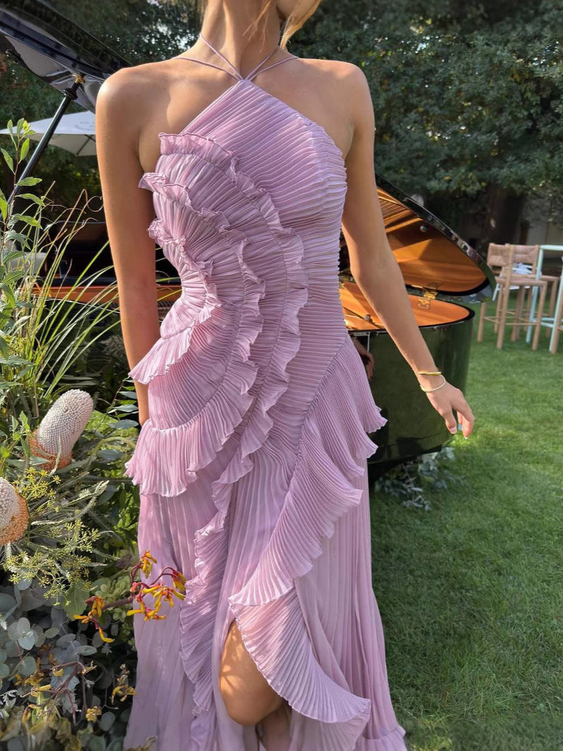 Primer plano de vestido largo plisado de mujer, destacando el escote halter y los volantes decorativos.