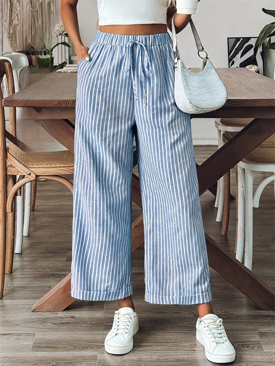 Pantalón de mujer fluido con estampado de rayas, perfecto para looks casuales o elegantes. Tejido ligero.
