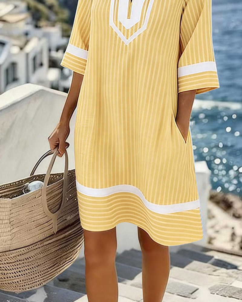 Mujer luciendo un vestido de rayas casual con cuello V y manga corta, ideal para el verano.